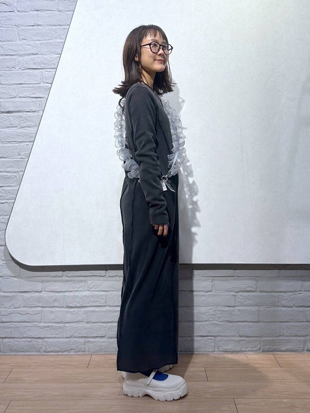 ホワイト系のスニーカー、グレー系のワンピース、グレー系のスマホグッズを着用したレディースの秋コーディネートの2枚目の写真