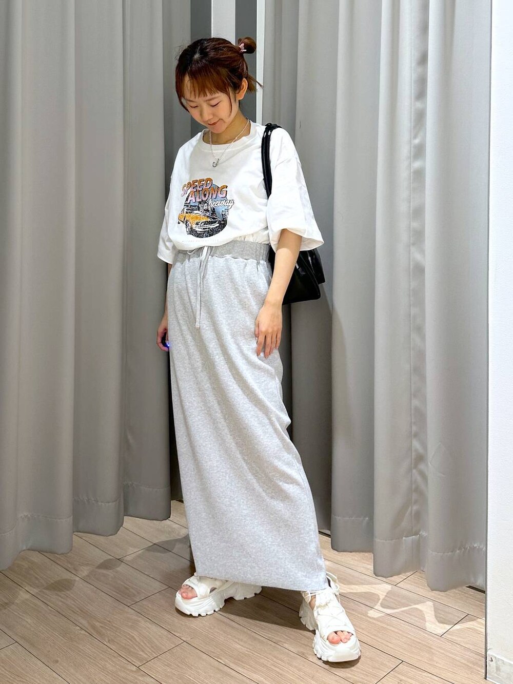 グレー系のスカート、ホワイト系のサンダル、ホワイト系のTシャツ/カットソーを着用したレディースの夏コーディネートの4枚目の写真