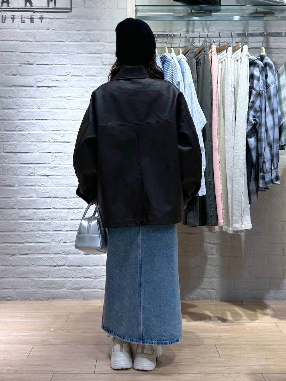 シルバー系のボストンバッグ、ベージュ系のスニーカー、ブラック系のブルゾンを着用したレディースの冬コーディネートの4枚目の写真