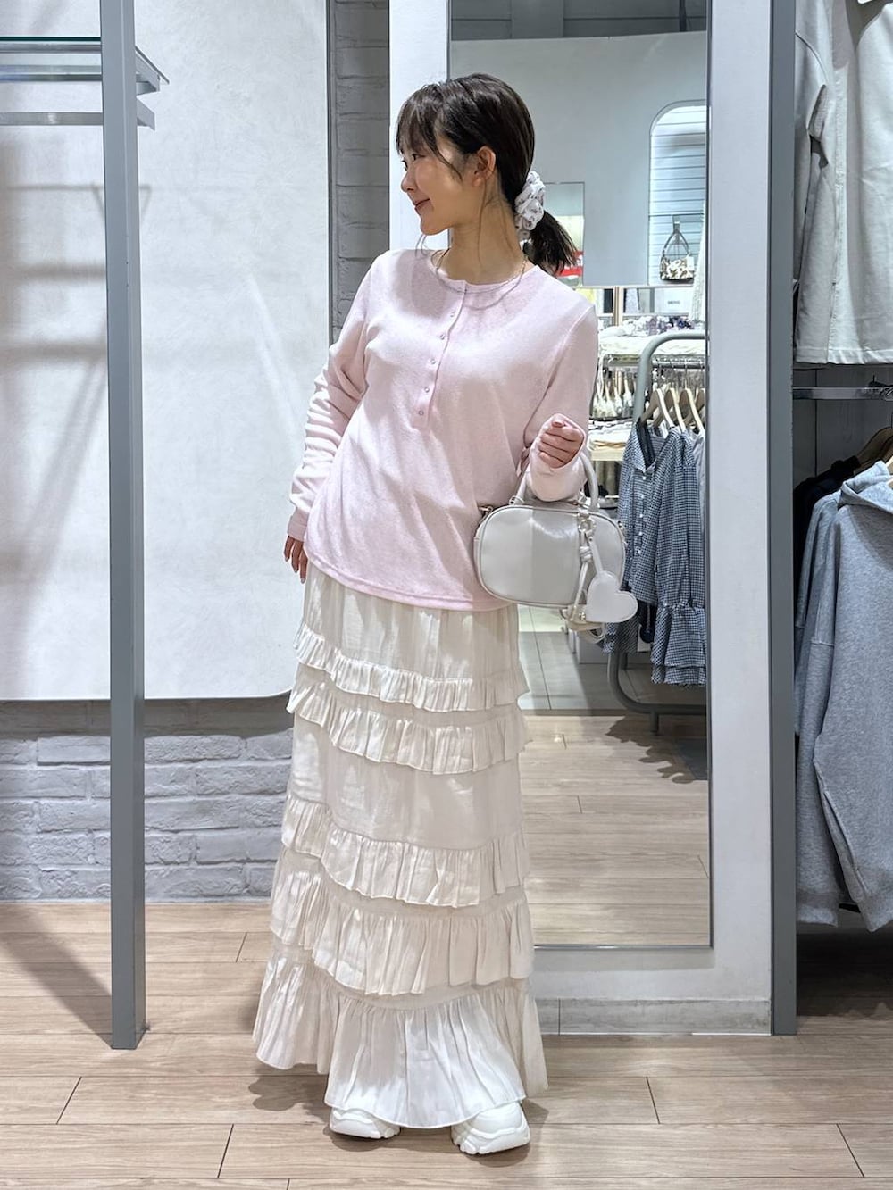 ホワイト系のボストンバッグ、ピンク系のTシャツ/カットソー、ホワイト系のスカートを着用したレディースの春コーディネートの2枚目の写真