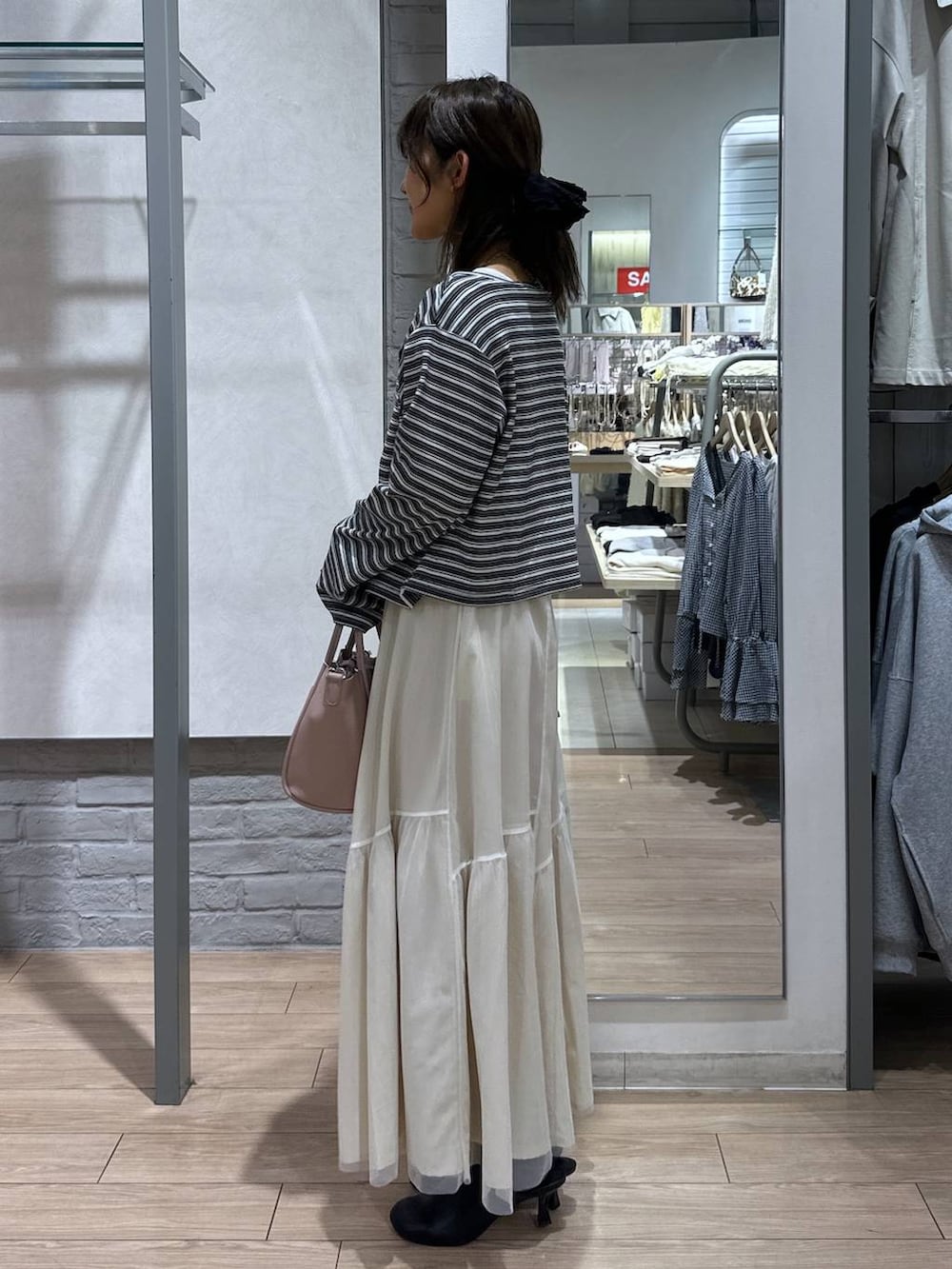 ピンク系のショルダーバッグ、ブラック系のサンダル、ホワイト系のニット/セーターを着用したレディースの春コーディネートの3枚目の写真