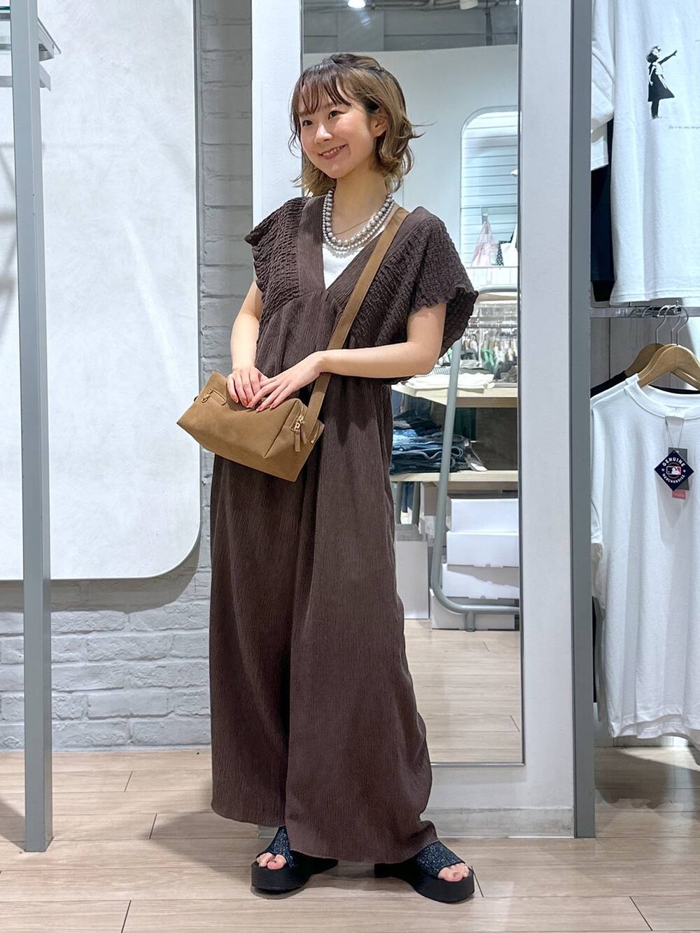 ホワイト系のTシャツ/カットソー、ブラック系のサンダル、ブラウン系のサロペット/オーバーオールを着用したレディースの夏コーディネートの2枚目の写真