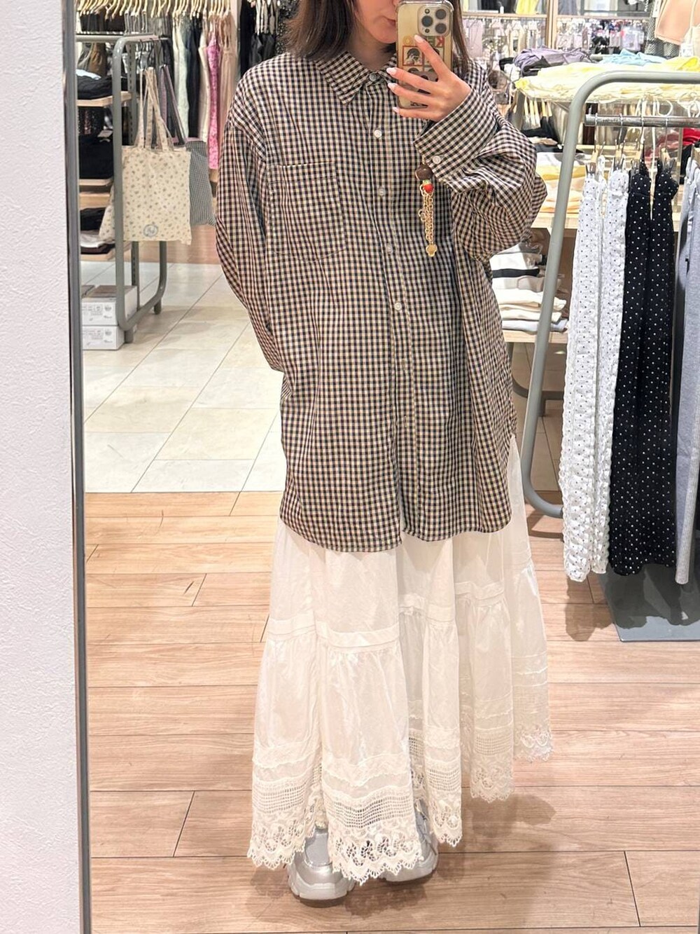 ピンク系のシャツ/ブラウス、ホワイト系のスカート、シルバー系のスニーカーを着用したレディースの春コーディネートの3枚目の写真