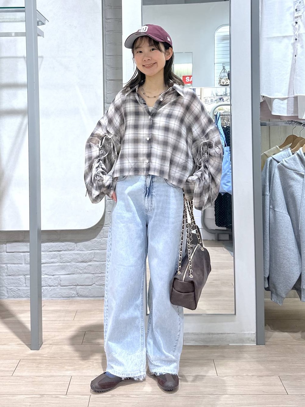 ホワイト系のTシャツ/カットソー、ブルー系のデニムパンツ、ブラウン系のショルダーバッグを着用したレディースの春コーディネートの2枚目の写真