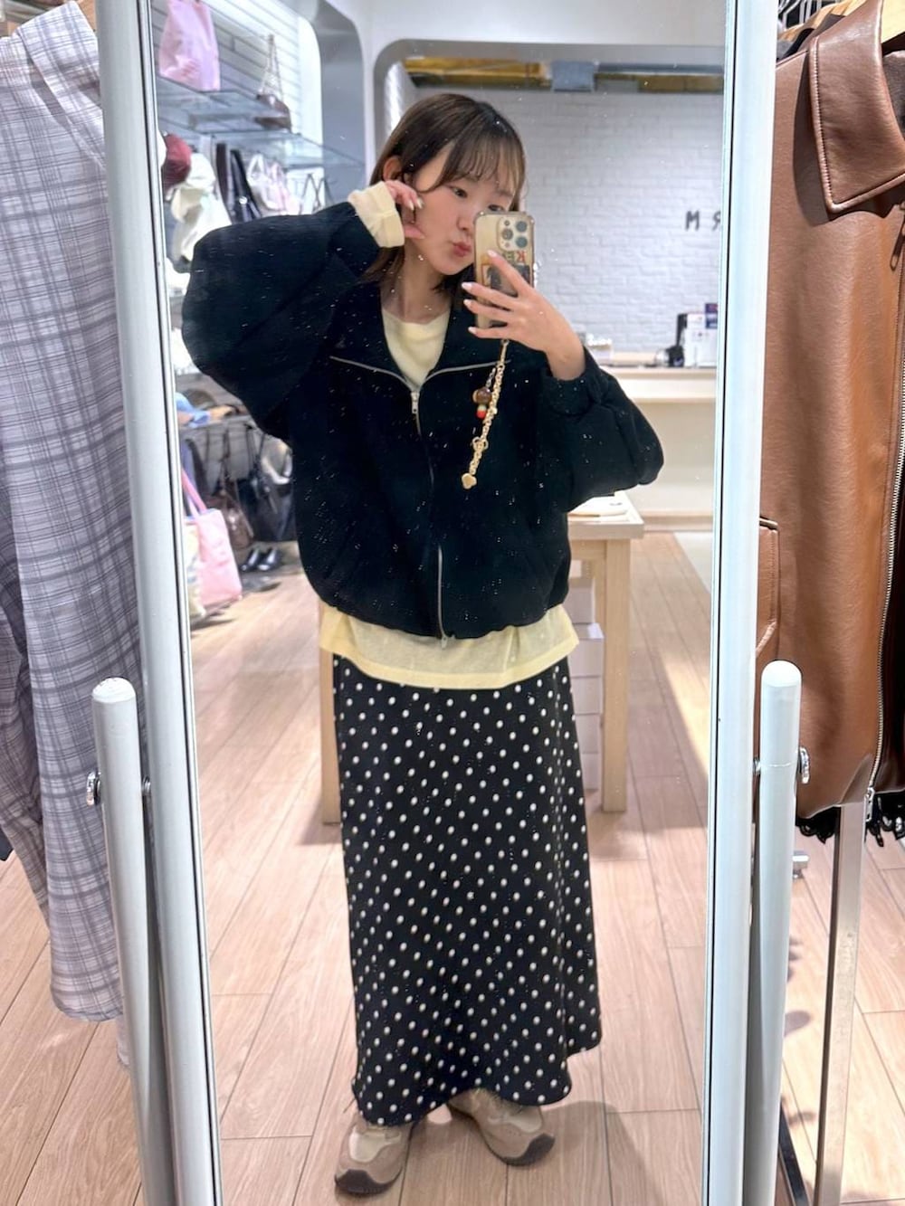 ブラック系のスカート、イエロー系のTシャツ/カットソー、ブラック系のスウェットを着用したレディースの春コーディネートの3枚目の写真