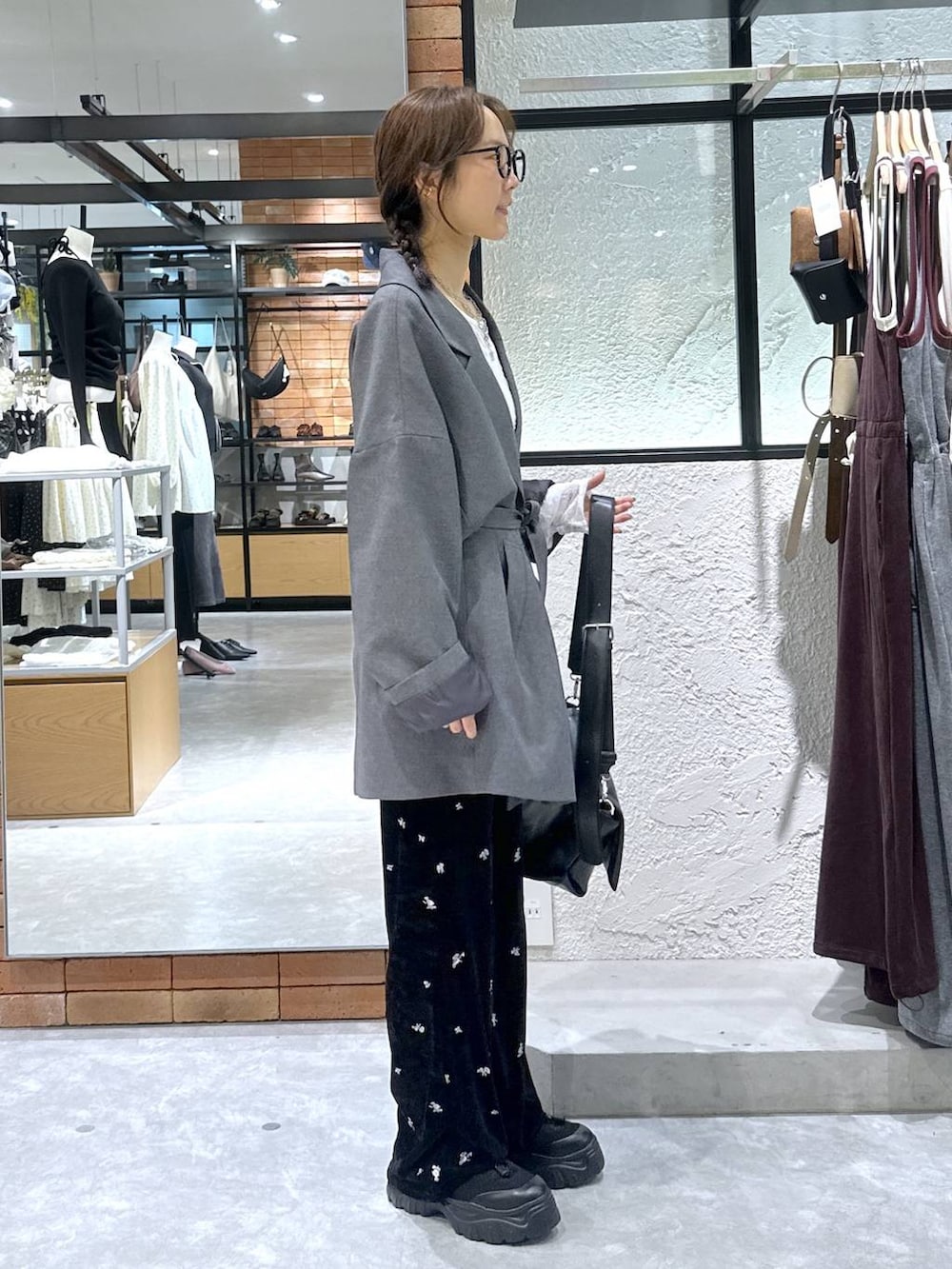 ブラック系のショルダーバッグ、ホワイト系のTシャツ/カットソー、ブラック系のスニーカーを着用したレディースの秋コーディネートの2枚目の写真