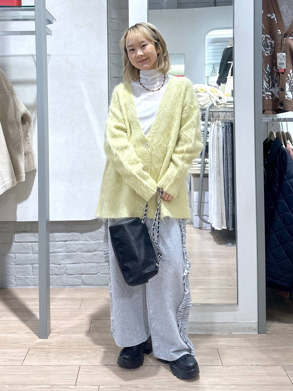 ブラック系のブーツ、イエロー系のカーディガン/ボレロ、グレー系のスウェットパンツを着用したレディースの秋コーディネートの2枚目の写真