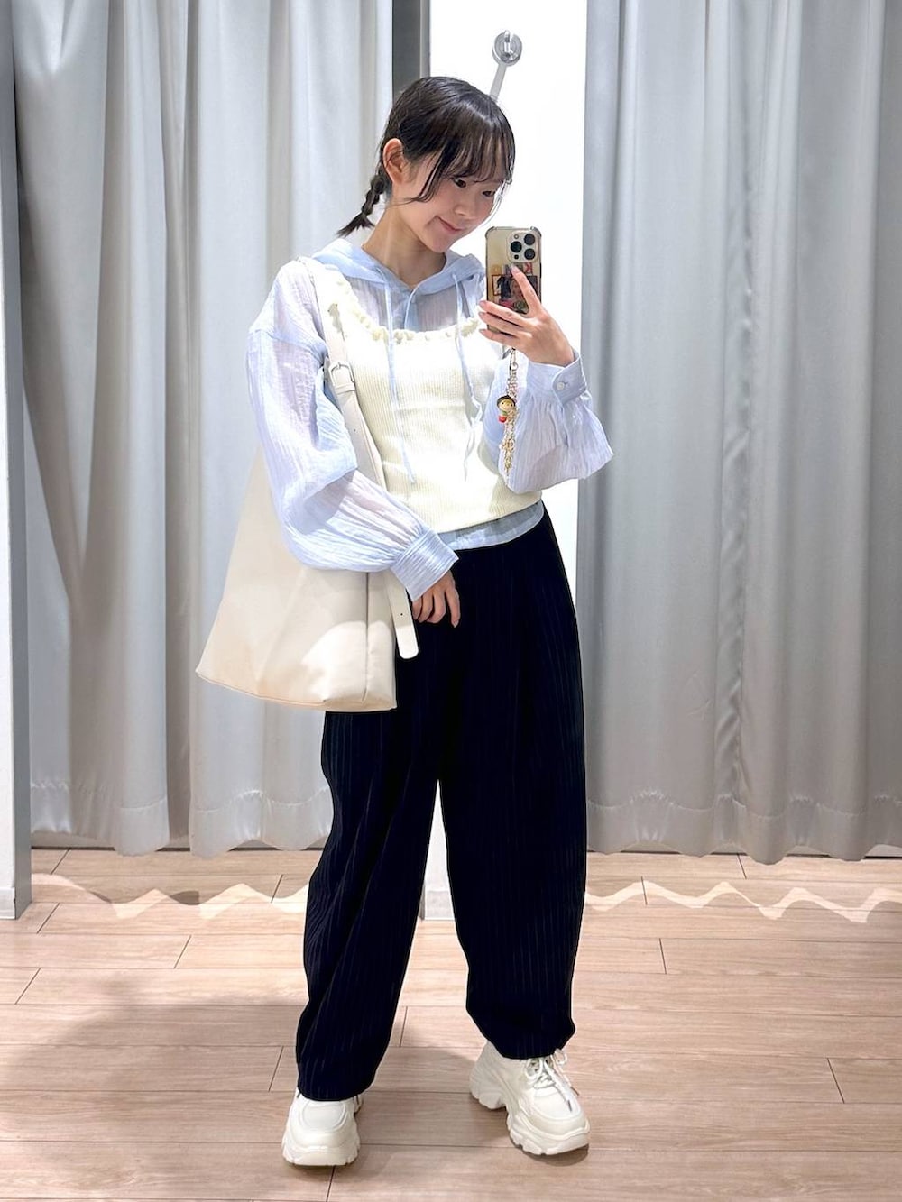 ホワイト系のショルダーバッグ、ブルー系のその他パンツ、ホワイト系のスニーカーを着用したレディースの春コーディネートの4枚目の写真