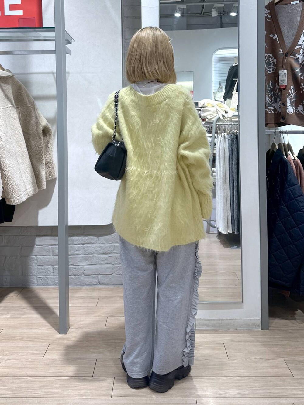 ブラック系のブーツ、イエロー系のカーディガン/ボレロ、グレー系のスウェットパンツを着用したレディースの秋コーディネートの5枚目の写真