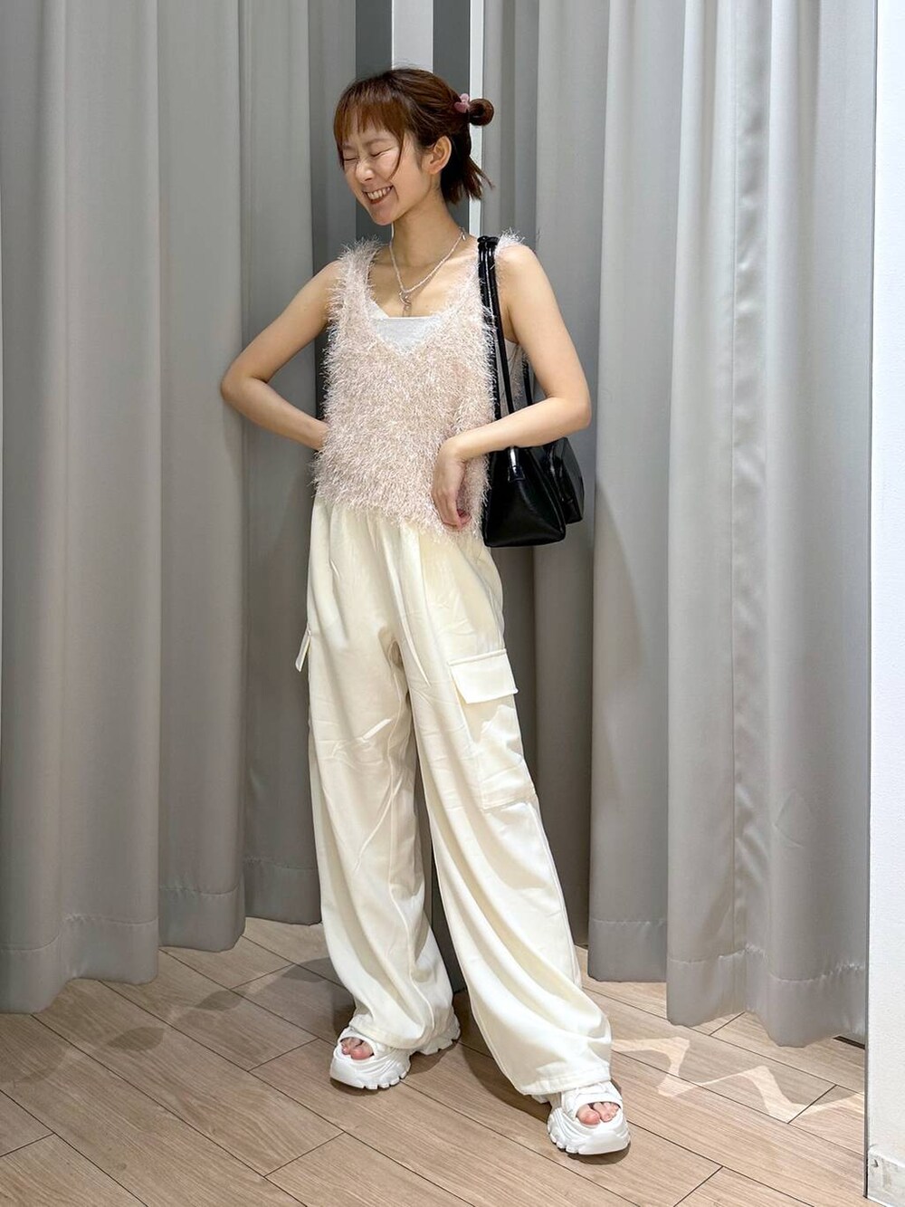 ホワイト系のサンダル、ホワイト系のキャミソール、ホワイト系のスラックスを着用したレディースの夏コーディネートの3枚目の写真