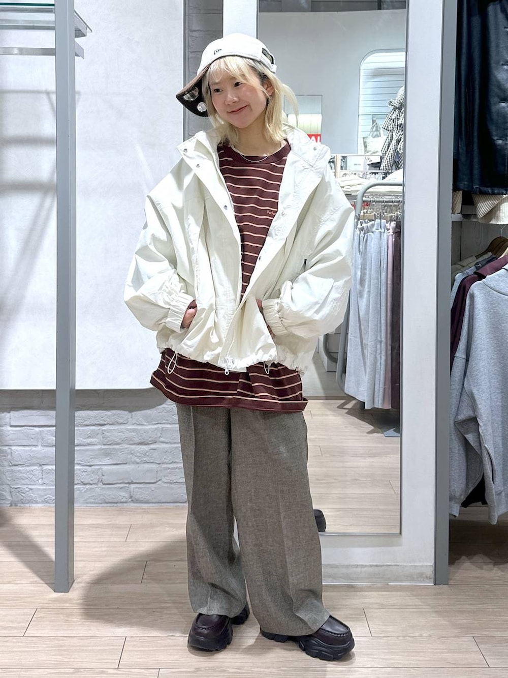 ホワイト系のナイロンジャケット、ブラウン系のデニムパンツ、ブラウン系のローファーを着用したレディースの冬コーディネートの4枚目の写真