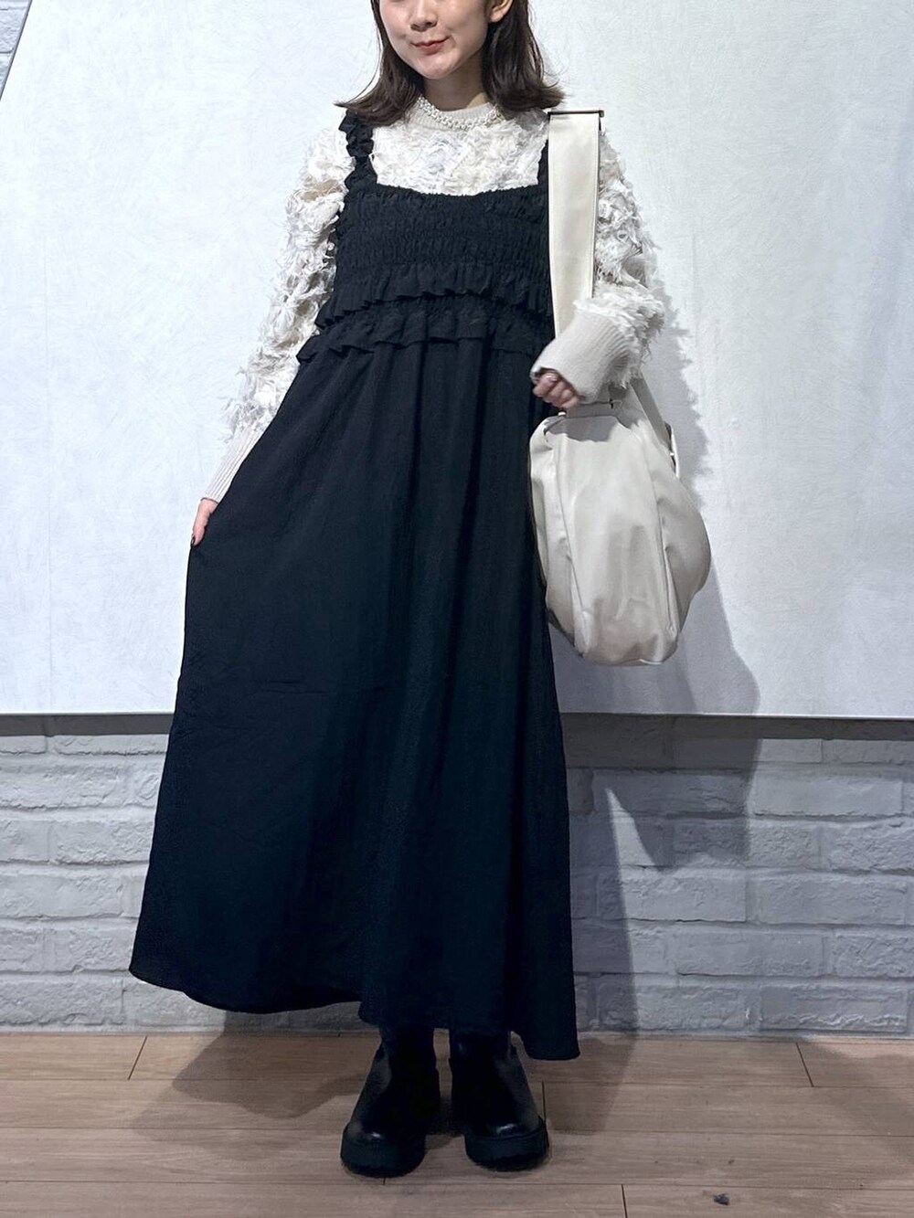 ホワイト系のボディバッグ/ウエストポーチ、ブラック系のワンピース、ホワイト系のニット/セーターを着用したレディースの秋コーディネートの4枚目の写真