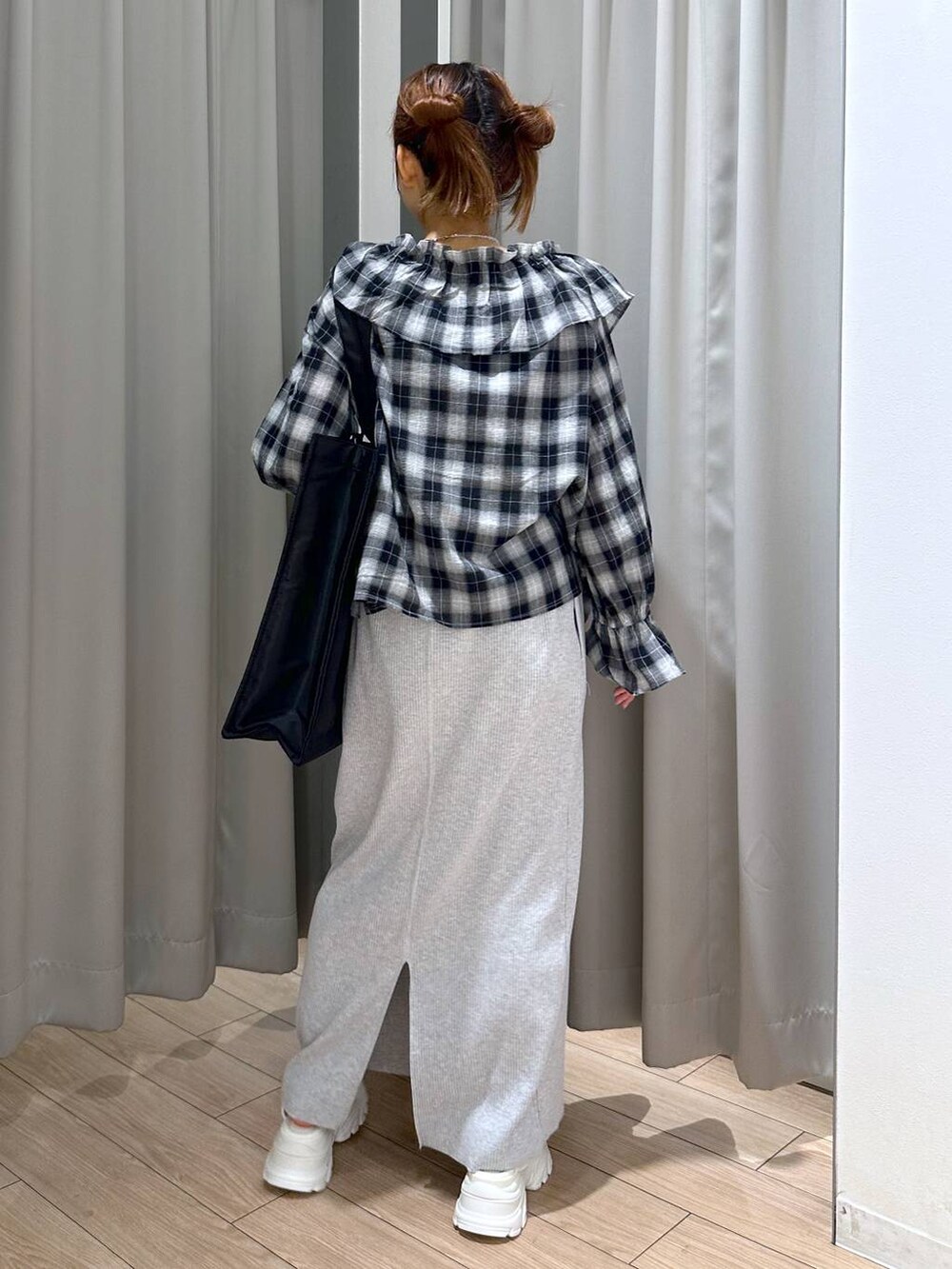 グレー系のスカート、ホワイト系のサンダル、ブラック系のトートバッグを着用したレディースの夏コーディネートの4枚目の写真