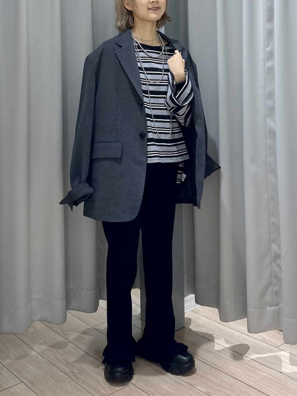 ブラック系のブーツ、グレー系のテーラードジャケット、ブラック系のその他パンツを着用したレディースの秋コーディネートの3枚目の写真