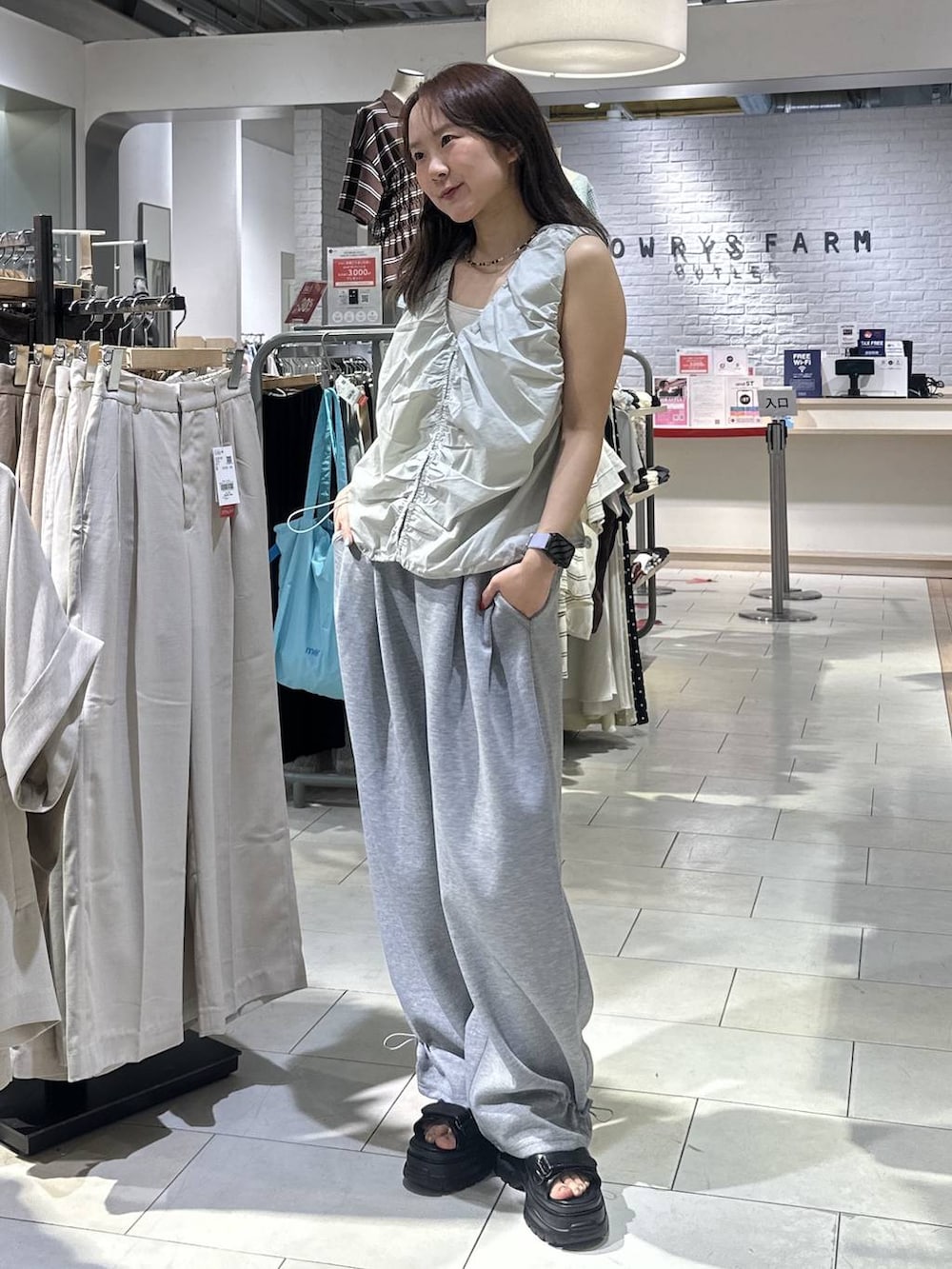 ホワイト系のTシャツ/カットソー、グレー系のスウェットパンツ、ブラック系のサンダルを着用したレディースの夏コーディネートの5枚目の写真
