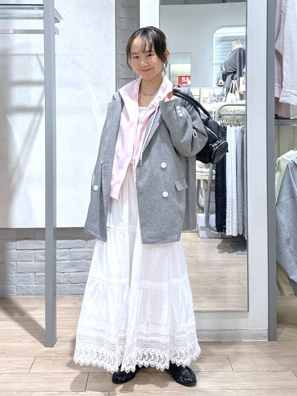 ホワイト系のTシャツ/カットソー、ピンク系のパーカー、グレー系のテーラードジャケットを着用したレディースの春コーディネートの2枚目の写真