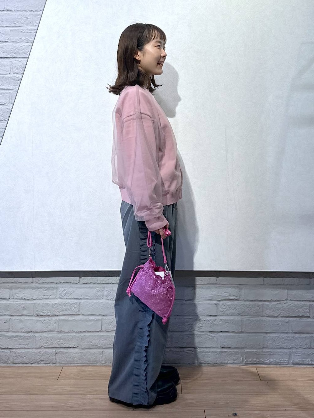 ピンク系のニット/セーター、ブラック系のブーツ、ピンク系のショルダーバッグを着用したレディースの秋コーディネートの3枚目の写真