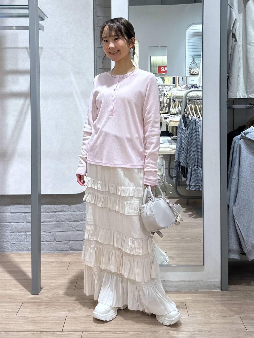 ホワイト系のボストンバッグ、ピンク系のTシャツ/カットソー、ホワイト系のスカートを着用したレディースの春コーディネートの4枚目の写真