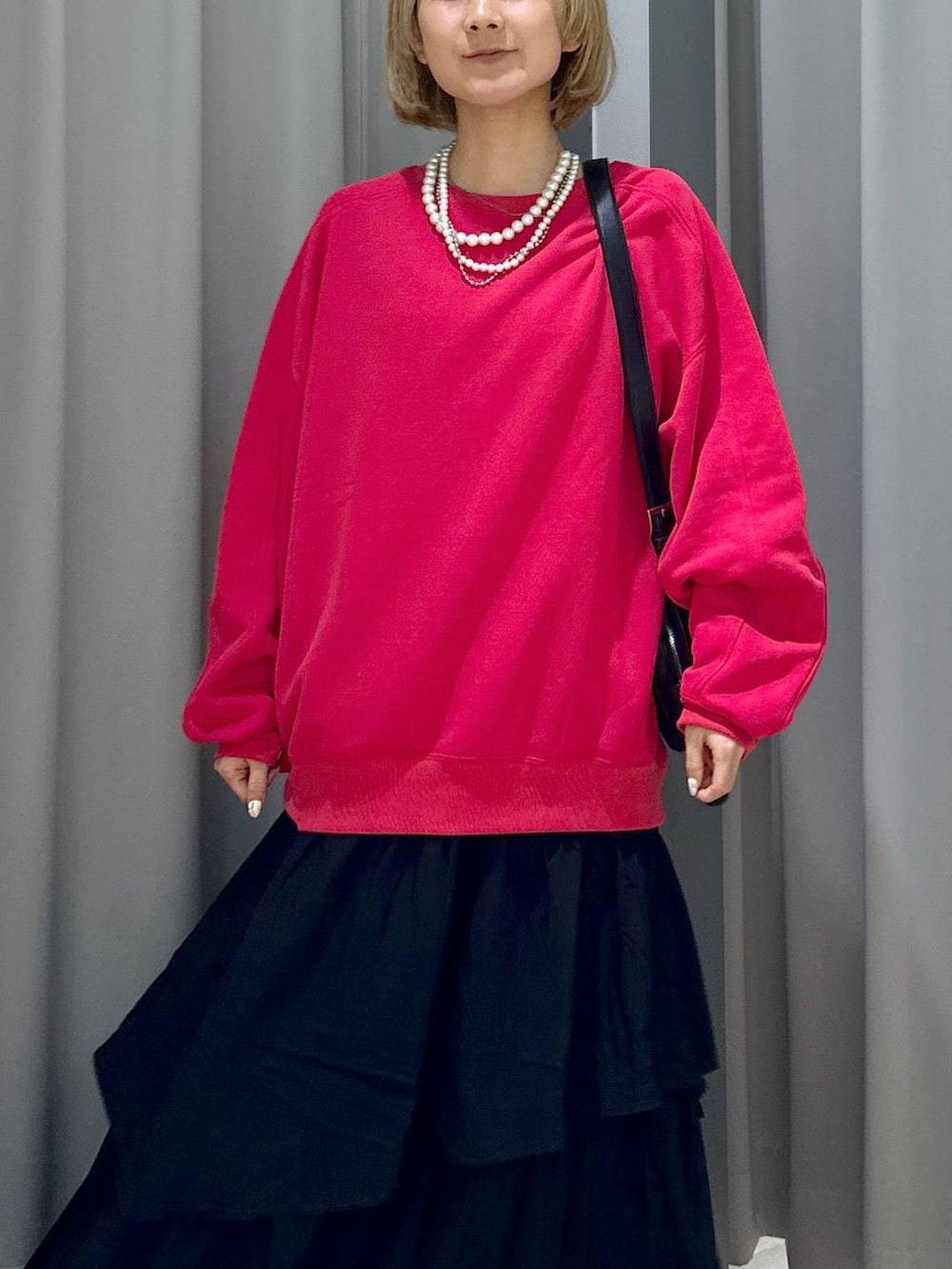 ブラック系のショルダーバッグ、レッド系のスウェット、シルバー系のスニーカーを着用したレディースの秋コーディネートの2枚目の写真