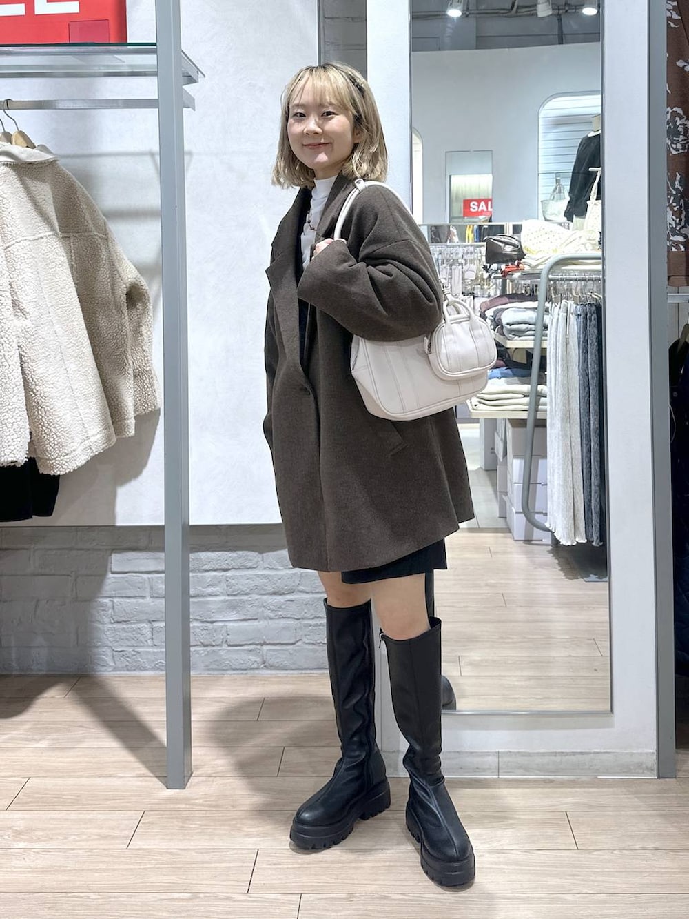 ブラウン系のその他アウター、ブラック系のその他パンツ、ブラック系のブーツを着用したレディースの冬コーディネートの4枚目の写真