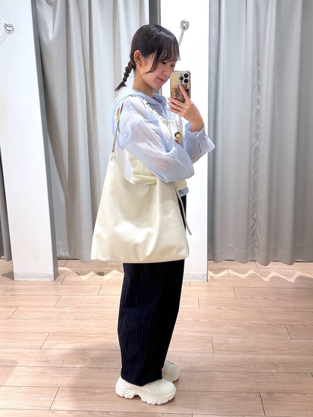 ホワイト系のショルダーバッグ、ブルー系のその他パンツ、ホワイト系のスニーカーを着用したレディースの春コーディネートの3枚目の写真