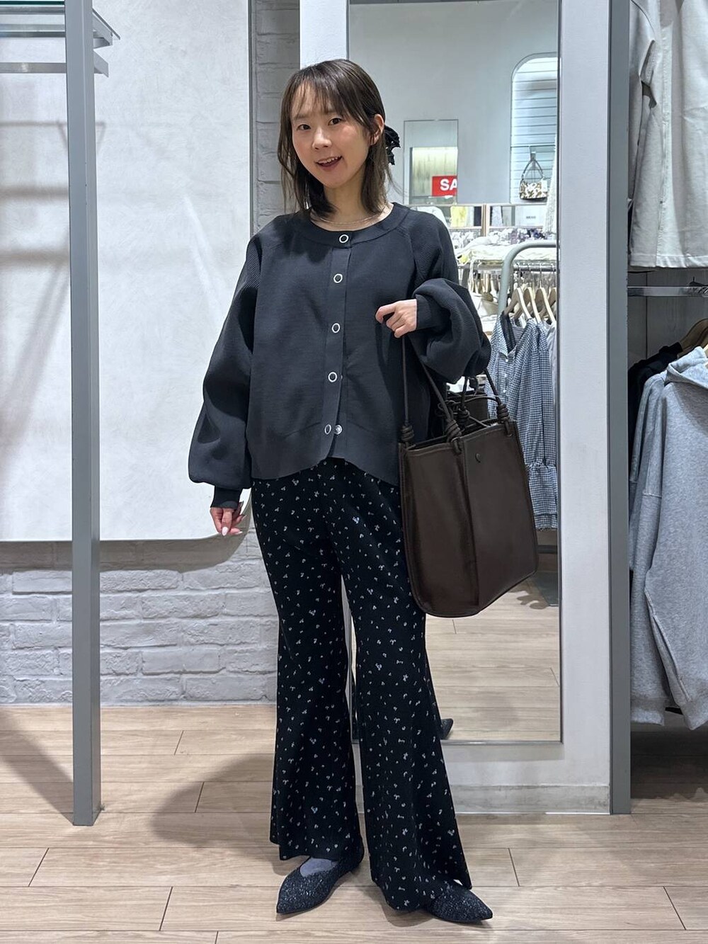 ブラック系のパンプス、ブラック系のその他パンツ、ブラウン系のトートバッグを着用したレディースの春コーディネートの2枚目の写真