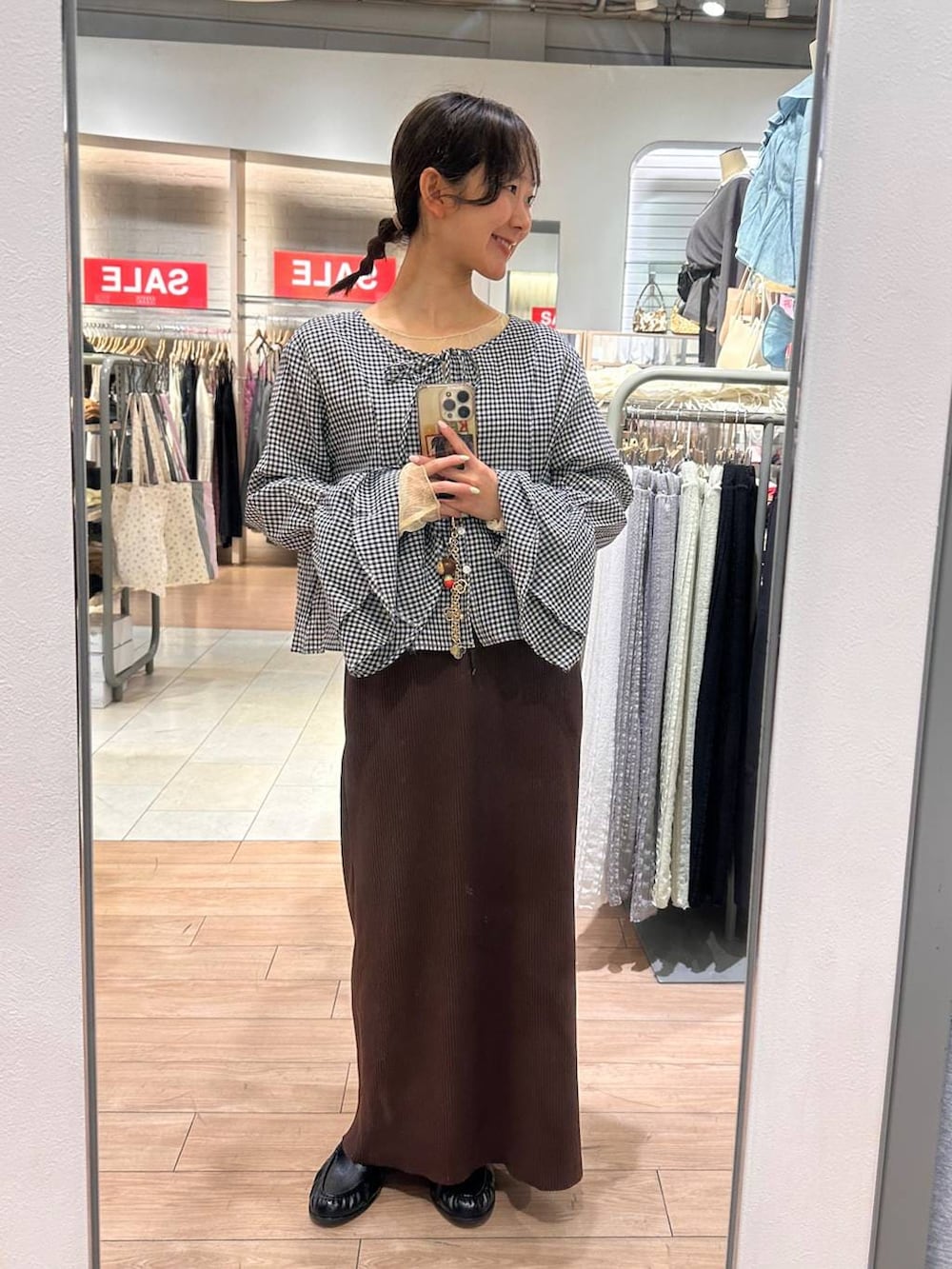 ブラウン系のスカート、ブラック系のローファー、ブラック系のシャツ/ブラウスを着用したレディースの春コーディネートの5枚目の写真