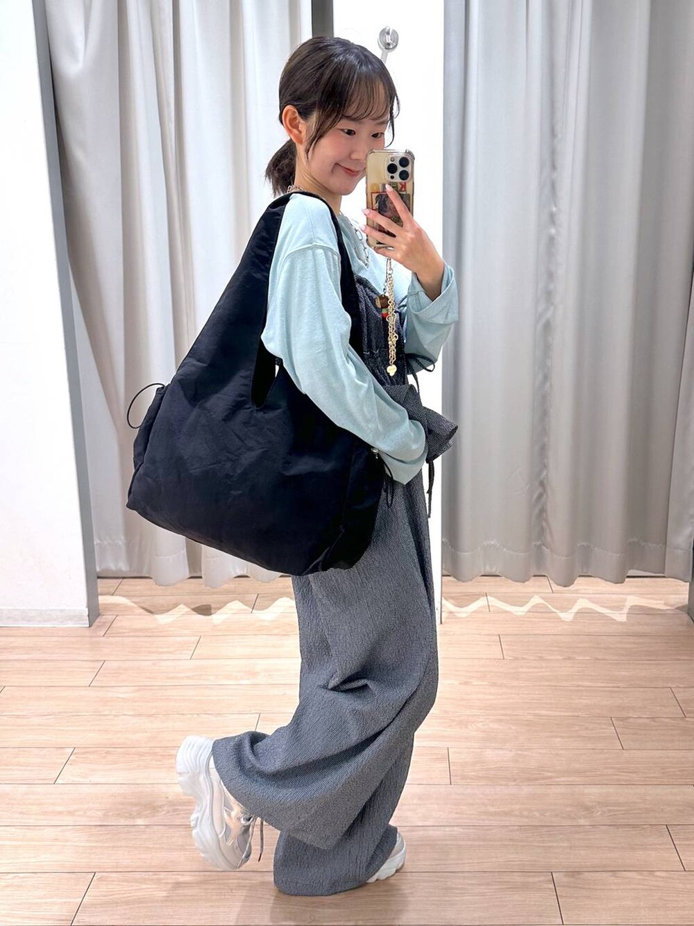 グリーン系のTシャツ/カットソー、ブラック系のトートバッグ、ブルー系のサロペット/オーバーオールを着用したレディースの春コーディネートの5枚目の写真