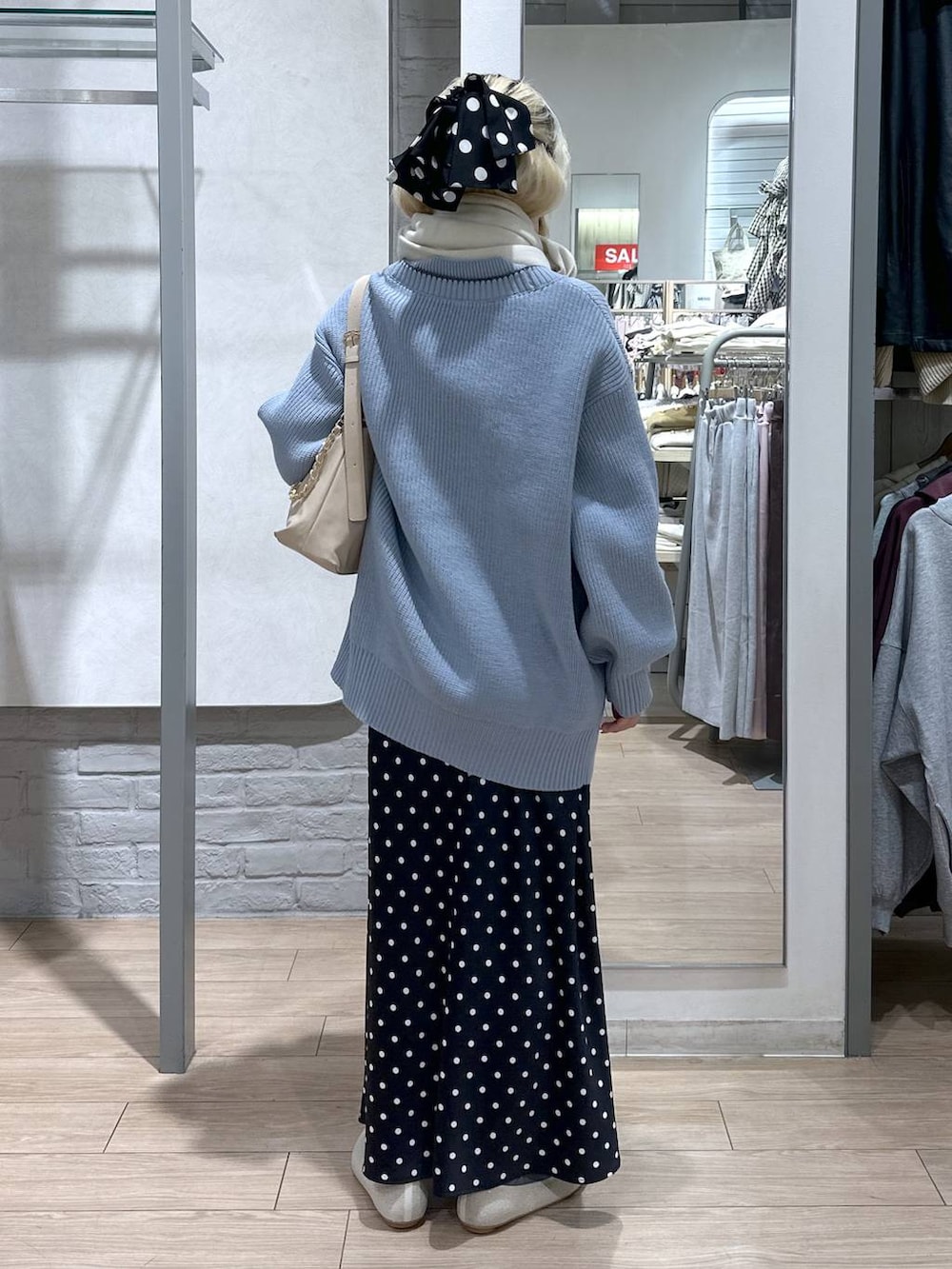 ブラック系のスカート、ブルー系のカーディガン/ボレロ、ホワイト系のパンプスを着用したレディースの冬コーディネートの4枚目の写真