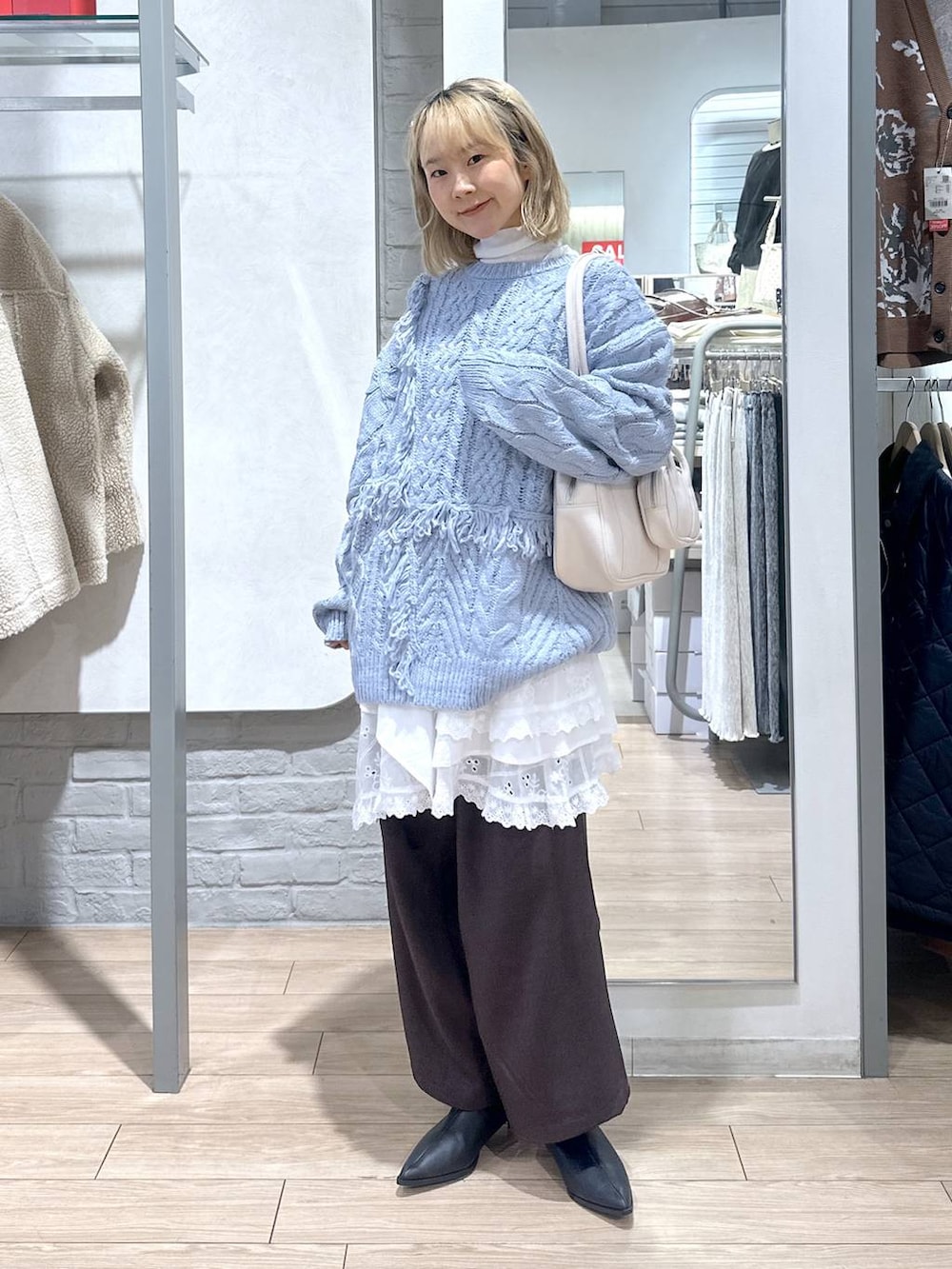 ブラウン系のその他パンツ、ホワイト系のスカート、ブルー系のニット/セーターを着用したレディースの秋コーディネートの4枚目の写真