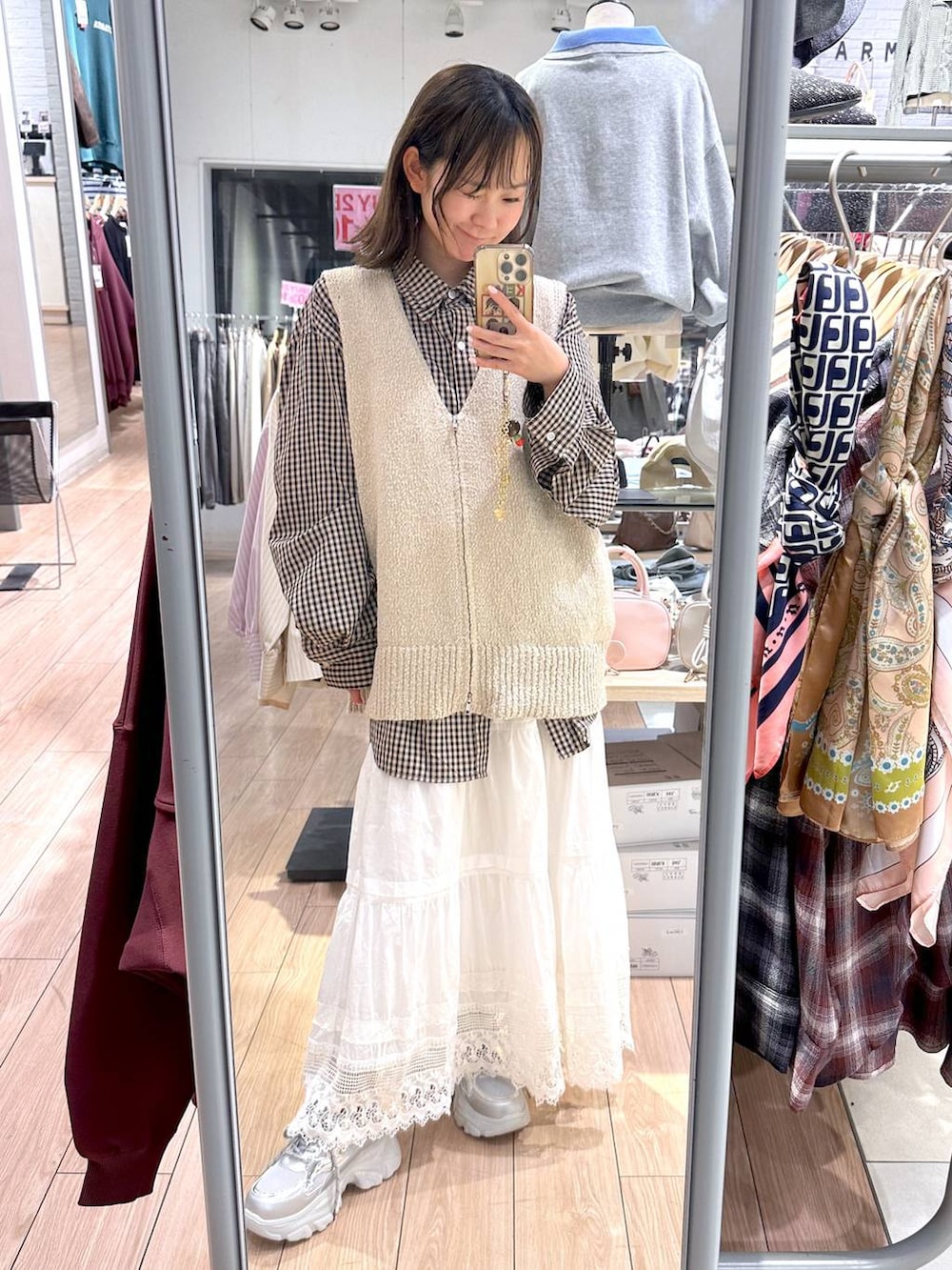 ブラウン系のシャツ/ブラウス、ベージュ系のベスト、ホワイト系のスカートを着用したレディースの春コーディネートの5枚目の写真