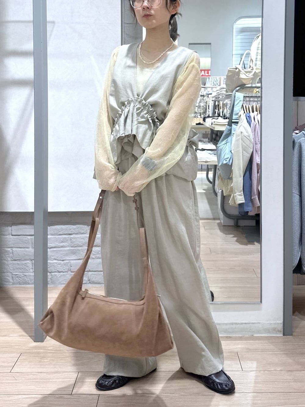 ゴールド系のタンクトップ、ブラック系のローファー、ブラウン系のショルダーバッグを着用したレディースの春コーディネートの3枚目の写真