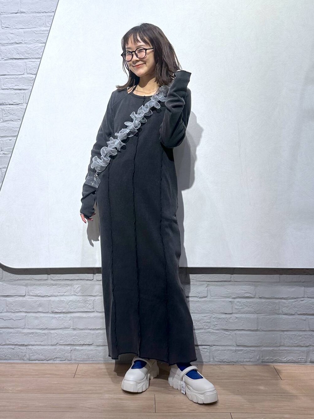 ホワイト系のスニーカー、グレー系のワンピース、グレー系のスマホグッズを着用したレディースの秋コーディネートの3枚目の写真