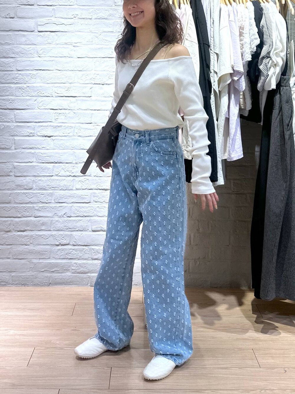 ブルー系のデニムパンツ、ホワイト系のTシャツ/カットソー、ホワイト系のスニーカーを着用したレディースの春コーディネートの5枚目の写真
