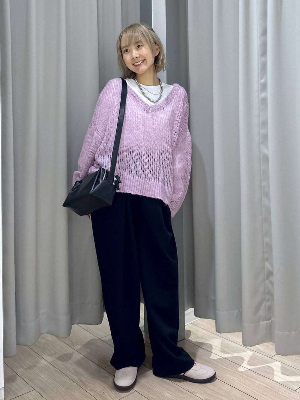 ピンク系のスニーカー、ブラック系のスウェットパンツ、ブラック系のショルダーバッグを着用したレディースの秋コーディネートの4枚目の写真