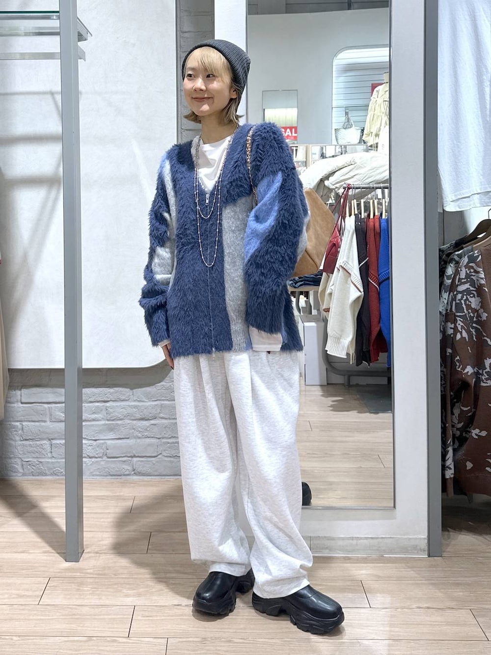 ブラック系のブーツ、ブルー系のカーディガン/ボレロ、グレー系のスウェットパンツを着用したレディースの秋コーディネートの3枚目の写真