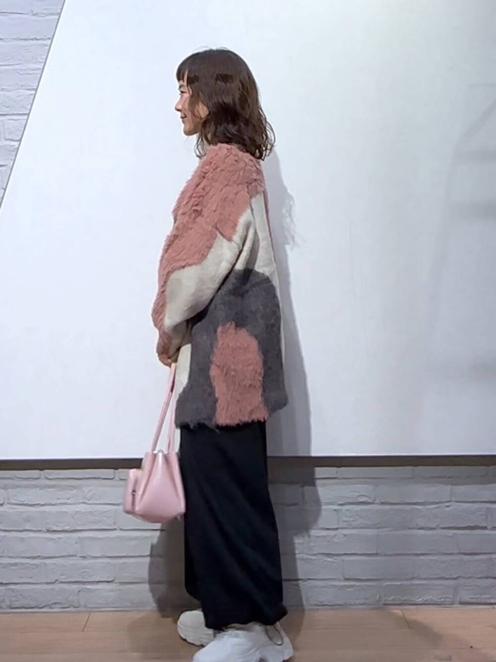 ブラック系のワンピース、ピンク系のショルダーバッグ、ホワイト系のスニーカーを着用したレディースの秋コーディネートの2枚目の写真