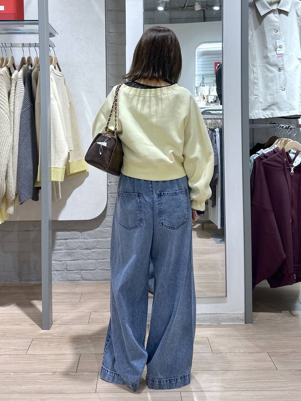 ブルー系のTシャツ/カットソー、ブラウン系のショルダーバッグ、ブルー系のデニムパンツを着用したレディースの春コーディネートの4枚目の写真