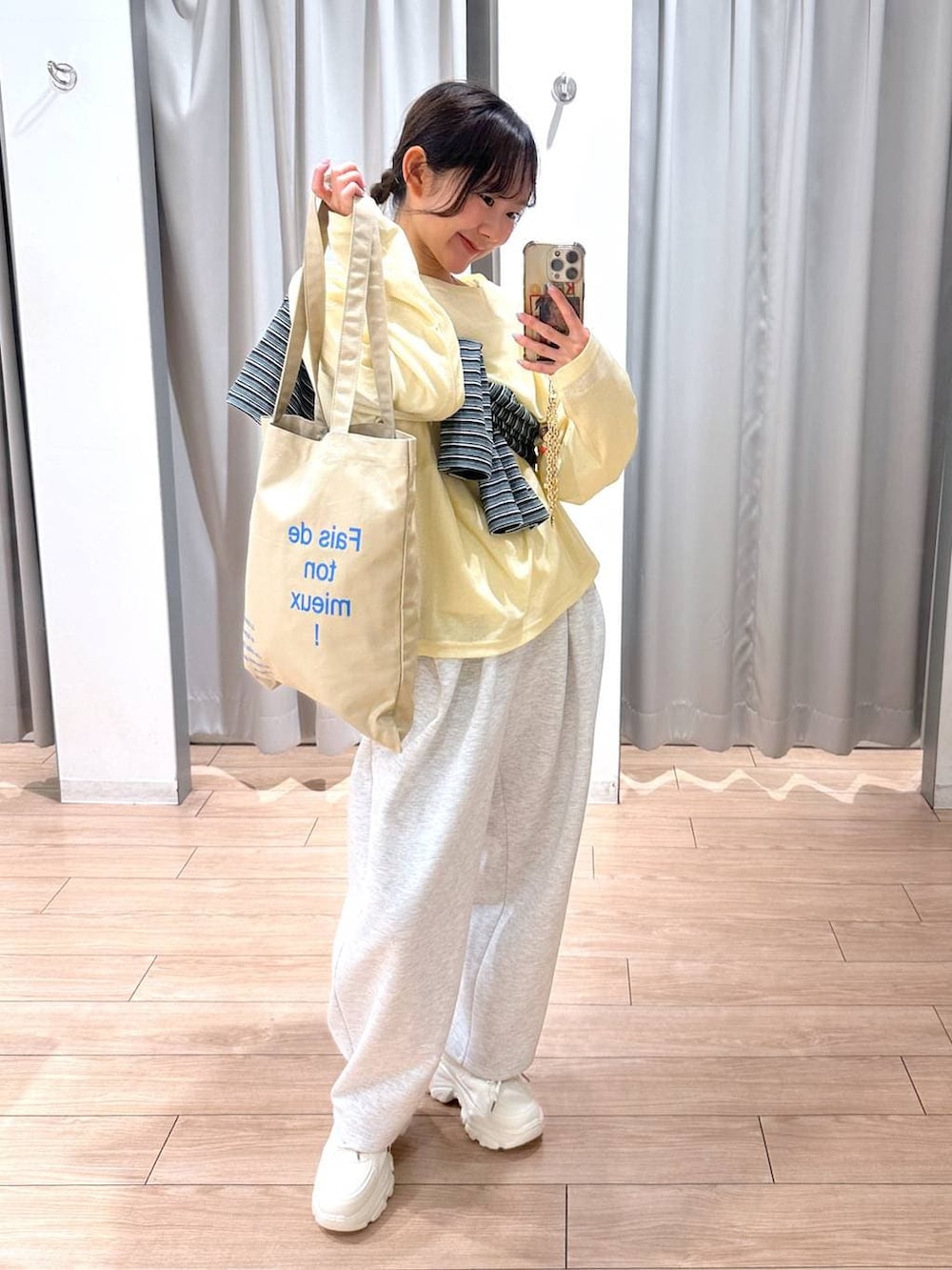 グレー系のスウェットパンツ、イエロー系のTシャツ/カットソー、ベージュ系のトートバッグを着用したレディースの春コーディネートの3枚目の写真
