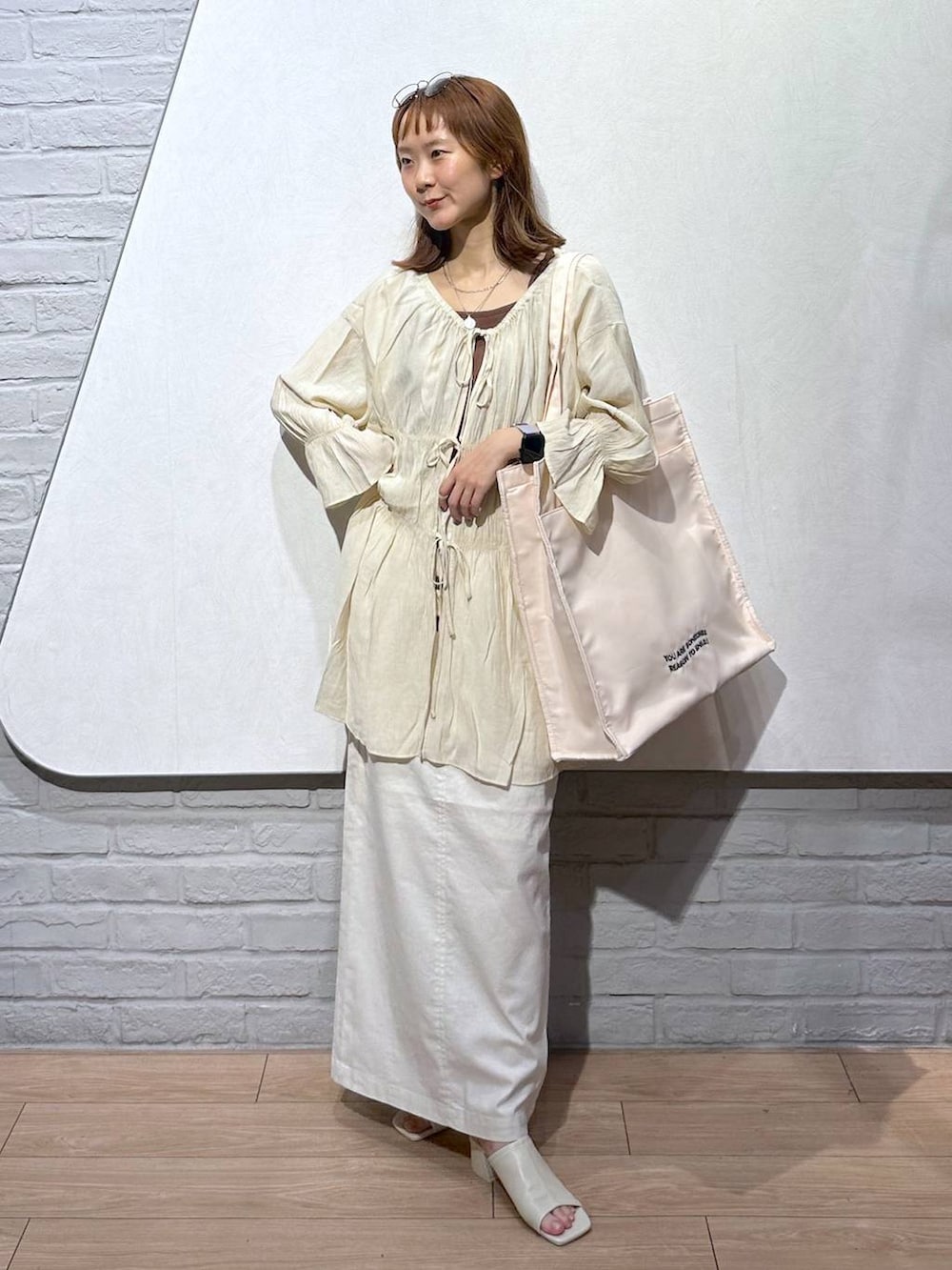 ブラウン系のTシャツ/カットソー、ホワイト系のトートバッグ、ホワイト系のスカートを着用したレディースの夏コーディネートの5枚目の写真