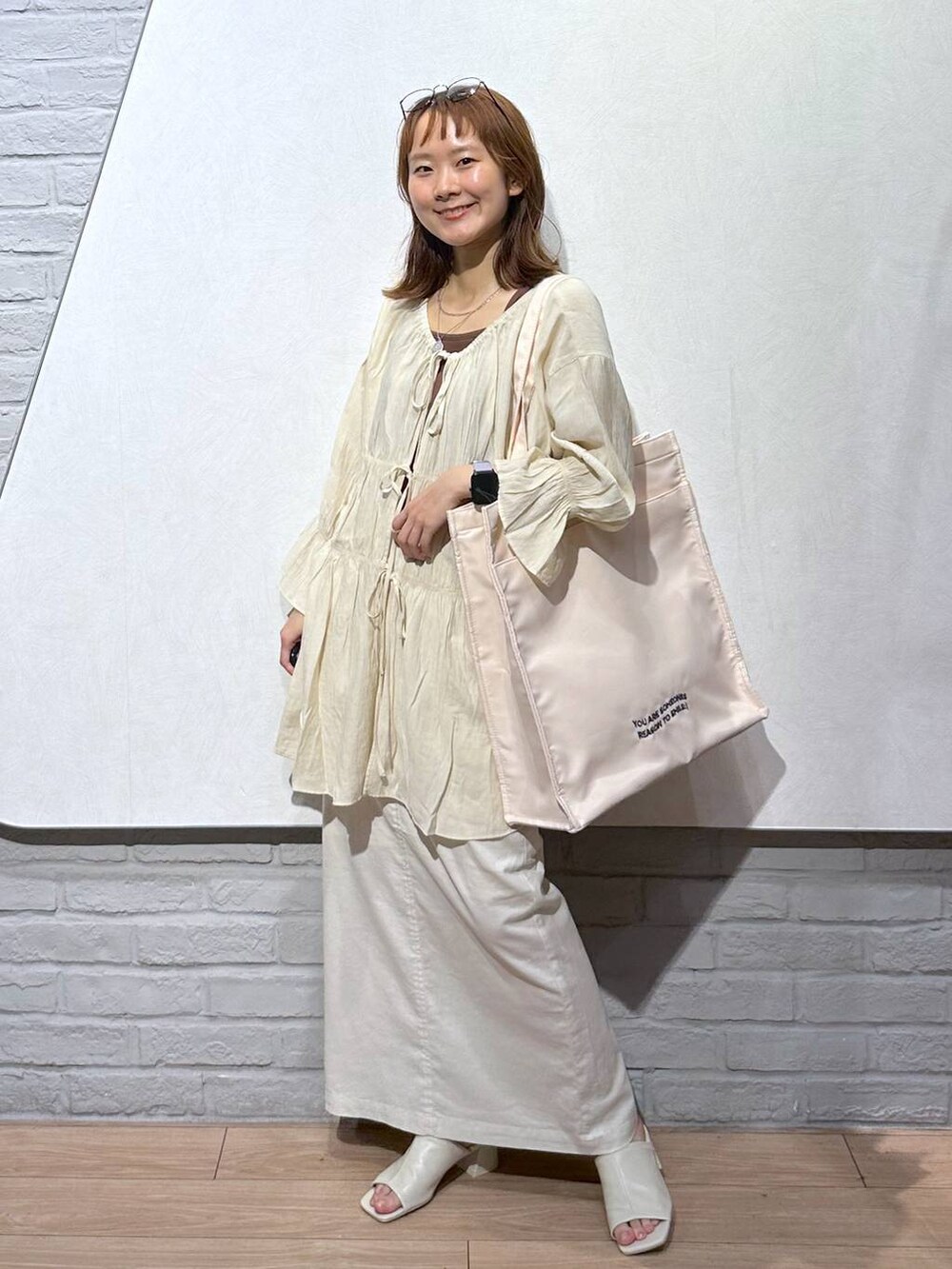 ブラウン系のTシャツ/カットソー、ホワイト系のトートバッグ、ホワイト系のスカートを着用したレディースの夏コーディネートの2枚目の写真