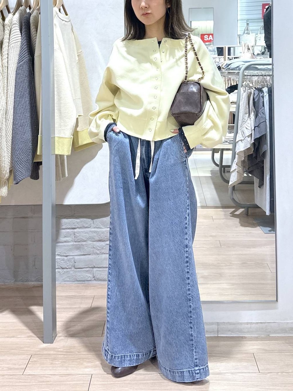 ブルー系のTシャツ/カットソー、ブラウン系のショルダーバッグ、ブルー系のデニムパンツを着用したレディースの春コーディネートの3枚目の写真