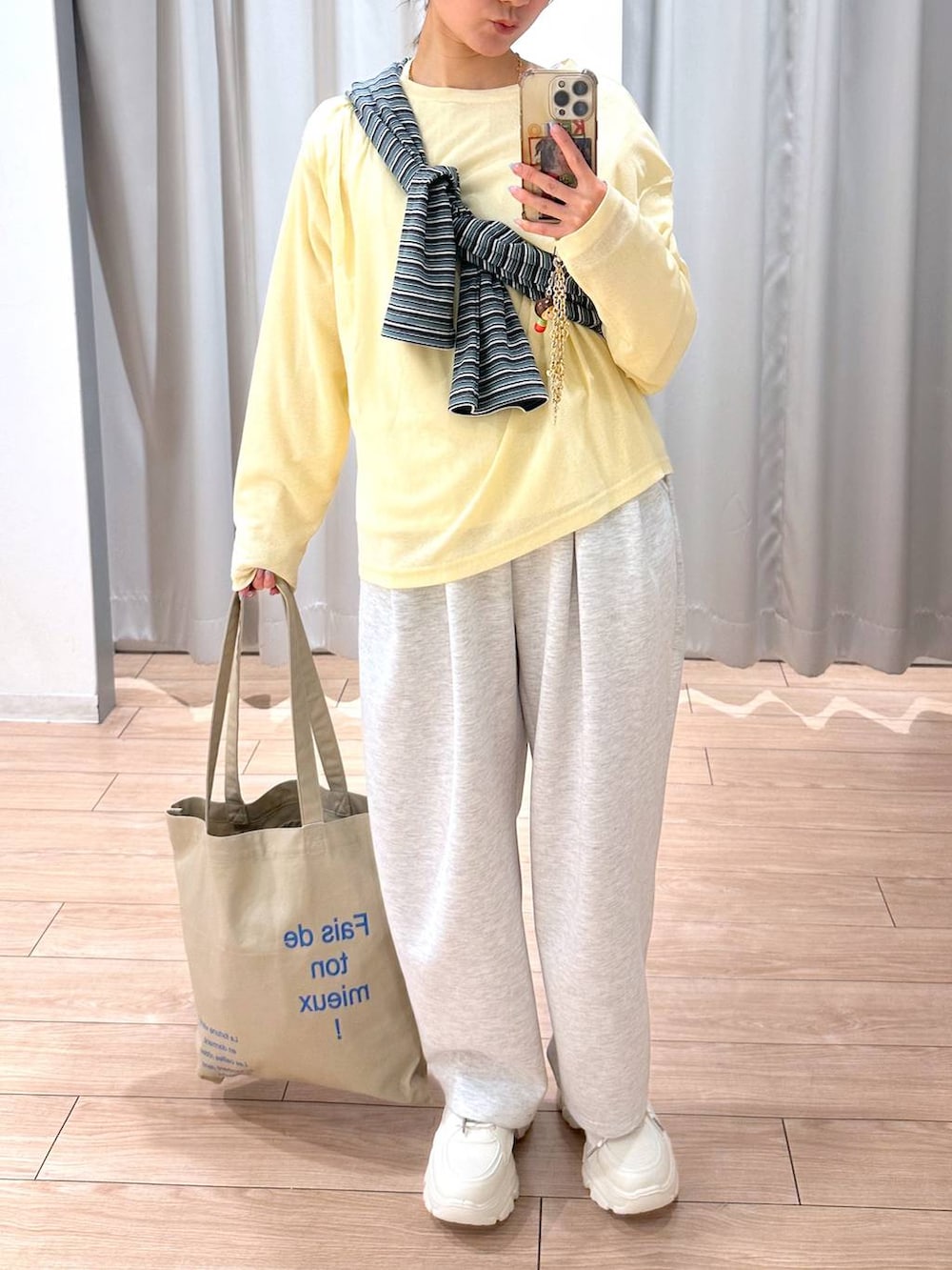グレー系のスウェットパンツ、イエロー系のTシャツ/カットソー、ベージュ系のトートバッグを着用したレディースの春コーディネートの4枚目の写真