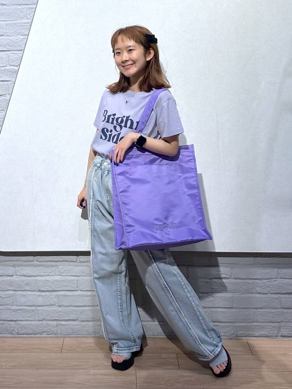 シルバー系のサンダル、パープル系のトートバッグ、ブルー系のデニムパンツを着用したレディースの夏コーディネートの5枚目の写真