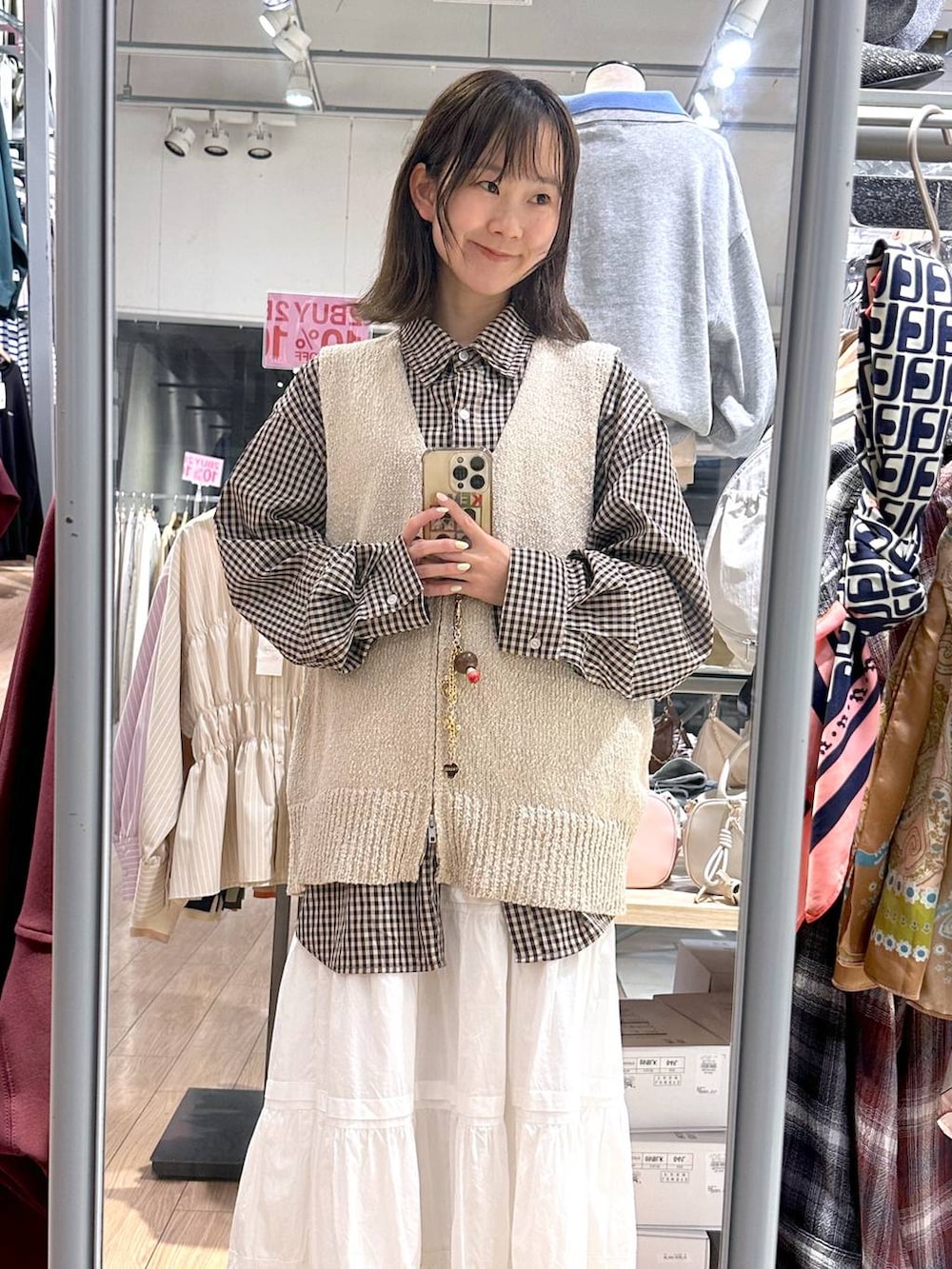 ブラウン系のシャツ/ブラウス、ベージュ系のベスト、ホワイト系のスカートを着用したレディースの春コーディネートの4枚目の写真