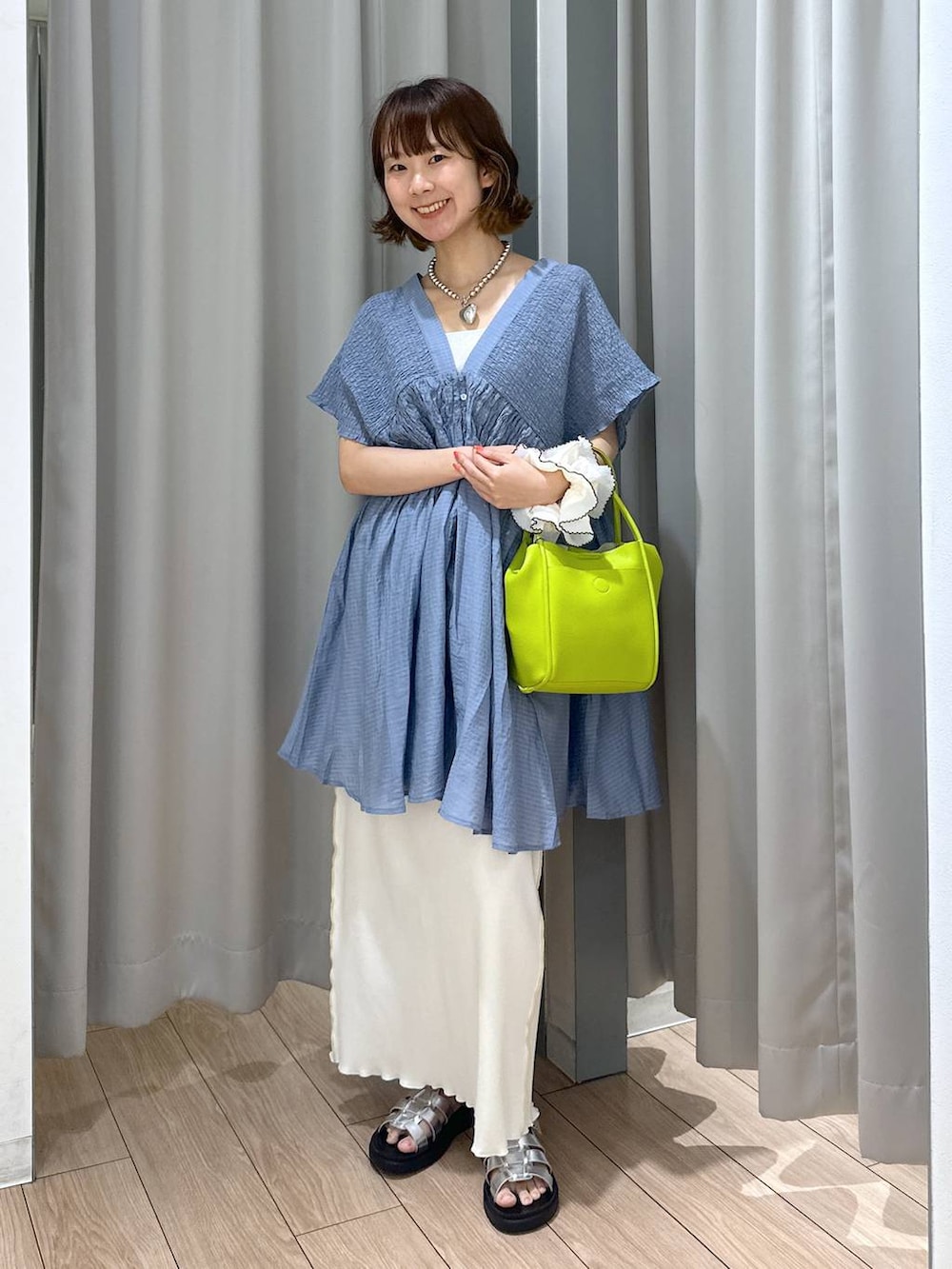 シルバー系のサンダル、シルバー系のタンクトップ、ホワイト系のスカートを着用したレディースの夏コーディネートの4枚目の写真