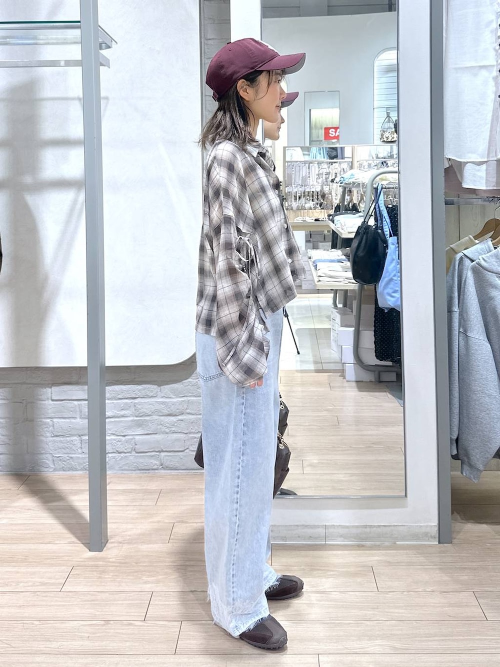 ホワイト系のTシャツ/カットソー、ブルー系のデニムパンツ、ブラウン系のショルダーバッグを着用したレディースの春コーディネートの4枚目の写真