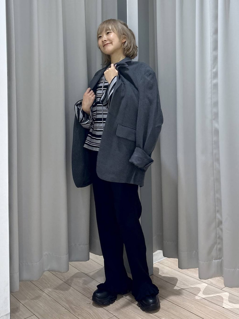 ブラック系のブーツ、グレー系のテーラードジャケット、ブラック系のその他パンツを着用したレディースの秋コーディネートの5枚目の写真