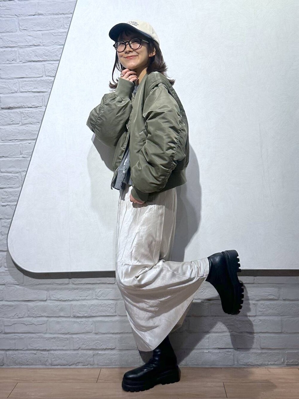 ブラック系のブーツ、ホワイト系のスカート、グレー系のスウェットを着用したレディースの秋コーディネートの3枚目の写真