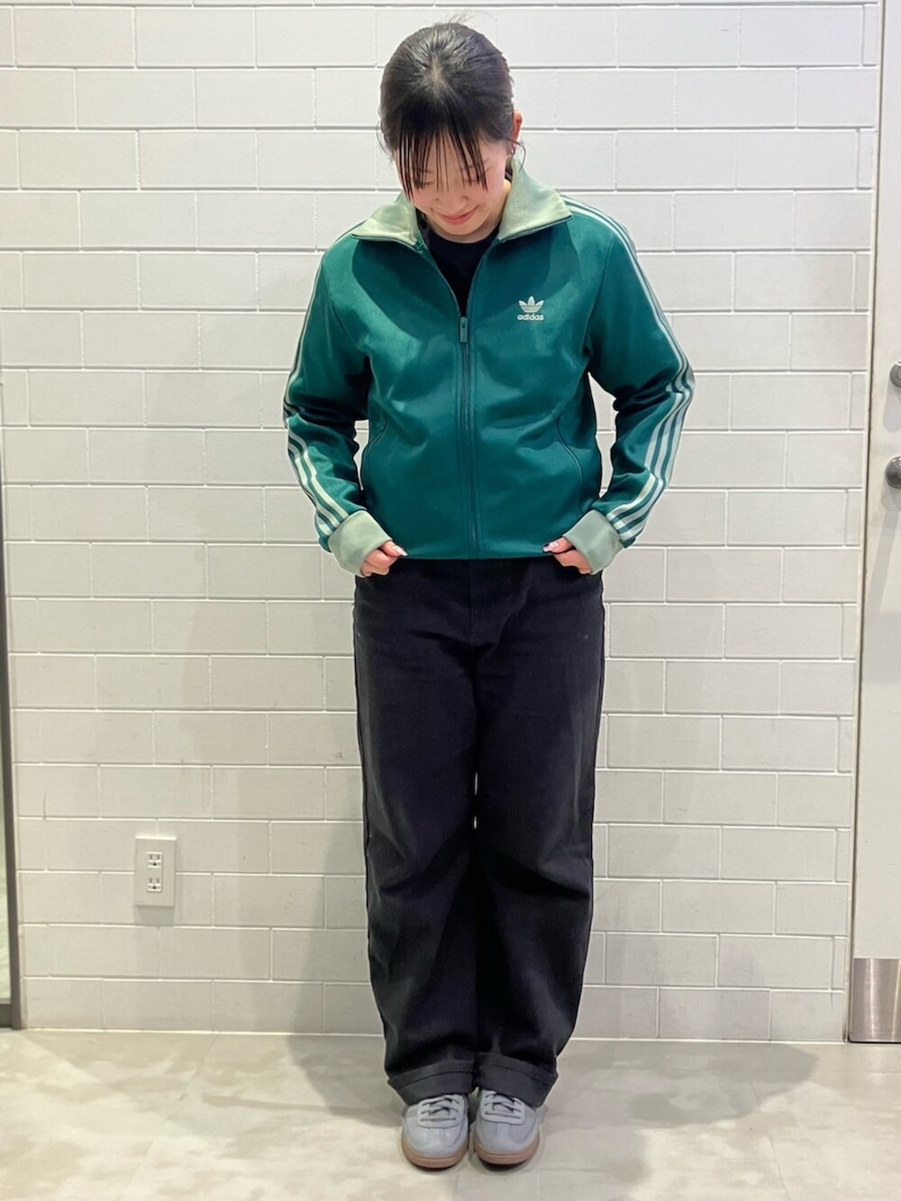 グレー系のスニーカー、グリーン系のジャージを着用したレディースの冬コーディネートの2枚目の写真